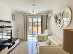 a living room with a couch and a television at Terrazas del Duque II Hideaway in Adeje
