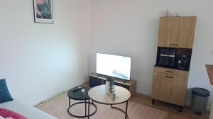 a room with a table and two chairs and a tv at La douce étoile ,12 minutes de disney in Bussy-Saint-Georges +3 photos