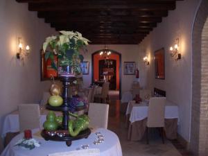 restauracja ze stołem z białymi stołami i krzesłami w obiekcie Hacienda Los Jinetes w mieście Carmona