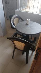 a table and a chair with a cup on it at studio avec salons séparé et balcon in Dakar