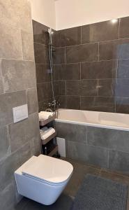 a bathroom with a toilet and a bath tub at Luxury Lavender Gorgeous Terrace Free UNDG Parking in Timişoara +14 photos