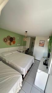 Un dormitorio con una cama, un escritorio y un televisor. en FLAT EM BARREIRINHAS - Gran Solare Lencois, en Barreirinhas