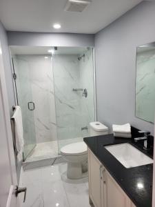 a bathroom with a shower and a toilet and a sink at Cozy 2 Bedroom Suite, 5 mins from Thermea Spa in Whitby