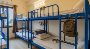 Una habitación con literas con literas azules y una mochila. en Hospitable Hostel, en Lahore