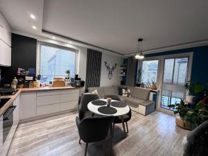 une cuisine et un salon avec une table et des chaises dans l'établissement pawel i tomek, à Ostróda