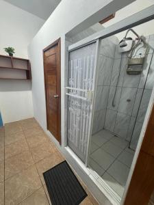 Un baño con ducha con puerta de cristal. en Alojamiento Villa Mar, en Puerto Ayora