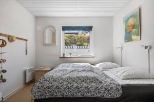 a bedroom with a bed and a window at 6836 Allinge - Fjeldvej 14 in Sandvig
