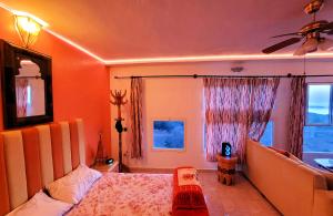 a bedroom with a bed and a couch and a window at Maison de la Lagune in Oualidia