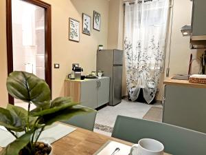 a kitchen with a table and a refrigerator at Maison DomInes in Ciampino