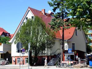 a man walking down a street in front of a building at Willa Muszelka - Apartamenty in Świnoujście