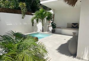 une piscine dans une cour arrière avec des palmiers dans l'établissement Mahalo Boutique B&B, à Popoyo