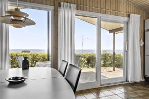 a dining room with a table and a view of the ocean at 6682 Allinge - Brunekulvej 2 E in Allinge