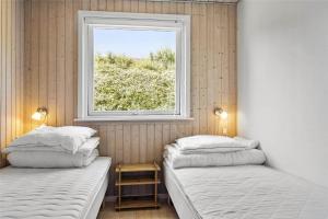 two beds in a room with a window at 6682 Allinge - Brunekulvej 2 E in Allinge