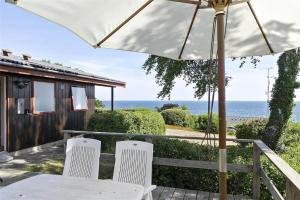 a patio with a table and two chairs and an umbrella at 6682 Allinge - Brunekulvej 2 E in Allinge