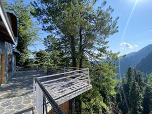 een balkon met uitzicht op een boom en de bergen bij 4BHK Dunga Gali in Dunga Gali