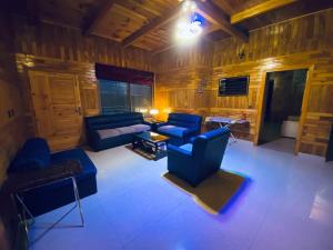 een woonkamer met blauwe stoelen en een bank bij 4BHK Dunga Gali in Dunga Gali