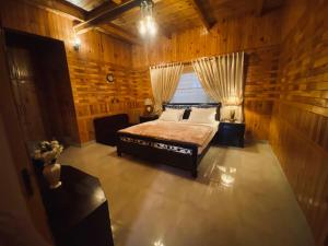 een slaapkamer met een bed in een houten kamer bij 4BHK Dunga Gali in Dunga Gali