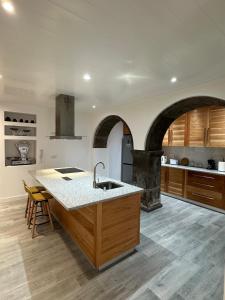 a kitchen with a counter and a sink and an oven at A Mercearia in Água de Pau