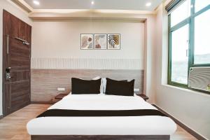 a bedroom with a large bed and a window at Hotel O Aman Paradise Hotel & Banquet in Kānpur +21 photos