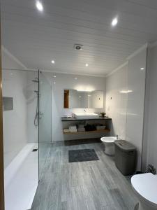 a bathroom with a shower and a toilet and a sink at A Mercearia in Água de Pau +30 photos