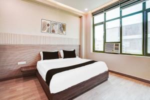 a bedroom with a bed and a window at Hotel O Aman Paradise Hotel & Banquet in Kānpur