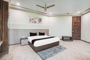 a bedroom with a bed and a ceiling fan at FabHotel Aman Paradise in Kānpur +15 photos