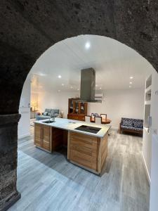 a kitchen with an archway in the middle of a room at A Mercearia in Água de Pau