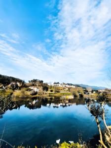 vista su un lago con case sullo sfondo di Serração House - Gerês a Rio Caldo