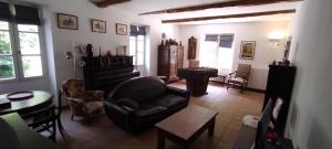 a living room with a couch and a piano at Le Mas in Entrechaux