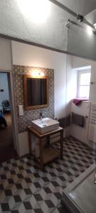 a bathroom with a sink and a checkered floor at Le Mas in Entrechaux