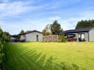 a large yard with a house and a house at Holiday home Ūdensrozes in Pērkone