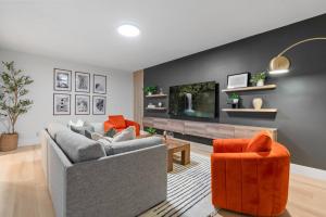 ein Wohnzimmer mit zwei Sofas und einem Fernseher in der Unterkunft 3 mi Downtown Spartanburg | Cozy+Modern | Pets OK in Spartanburg