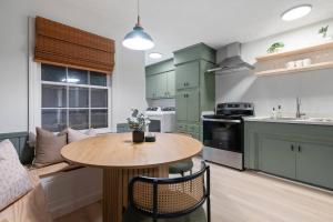 eine Küche mit grünen Schränken und einem Holztisch in der Unterkunft 3 mi Downtown Spartanburg | Cozy+Modern | Pets OK in Spartanburg