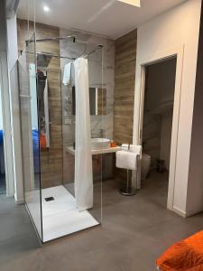 a bathroom with a glass shower and a sink at Le Saline Rooms Marzamemi in Marzamemi