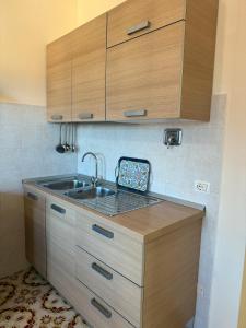 a small kitchen with a sink and wooden cabinets at Apartment Celeste - Isola D'elba in San Giovanni +12 photos
