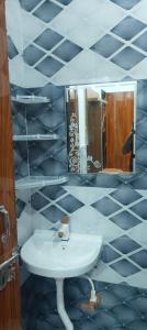 une salle de bain avec un lavabo et un miroir dans l'établissement Grand Place Near by Prem Mandir, à Jāmb