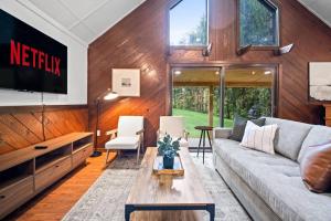 Una sala de estar con un sofá y un televisor. en 13min Summersville Lake | HotTub | FirePit | Quiet, en Summersville