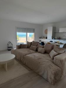 a large couch in a living room with a table at Appartement face à la mer 2 in Port-la-Nouvelle