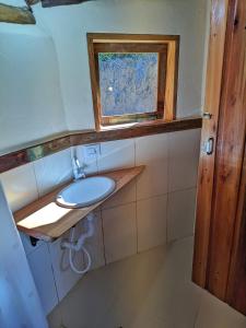 un bagno con lavandino e finestra di Casa Azul no Vale Matutu, Vista incrível e aconchego a Aiuruoca Altre 10 foto