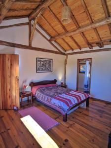 una camera da letto con un letto grande con soffitto in legno di Casa Azul no Vale Matutu, Vista incrível e aconchego a Aiuruoca