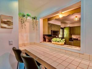 a kitchen with green cabinets and a counter with chairs at 17 Min to NRG | Grill | Huge Yard | Private | Cozy in Oak Hill