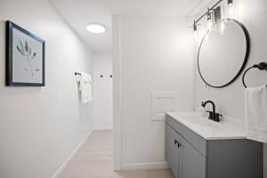 a white bathroom with a sink and a mirror at 10min to NRG | Hot tub | Sauna | Firepit | 4br 3ba in Oak Hill +64 photos