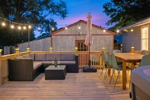 a patio with a couch and a table and chairs at 10min to NRG | Hot tub | Sauna | Firepit | 4br 3ba in Oak Hill