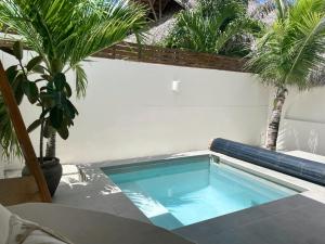 - une piscine au milieu d'un patio avec des palmiers dans l'établissement Mahalo Boutique B&B, à Popoyo