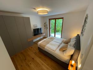 ein Schlafzimmer mit großem Bett und Fenster in der Unterkunft Mountain Fairy Tale in Bad Kleinkirchheim