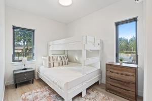 ein weißes Schlafzimmer mit einem Etagenbett und einem Fenster in der Unterkunft Family-Friendly Beachside Bliss in Oyster Bay