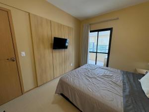 贝伦Modern Condo Doca in Umarizal的一间卧室，里面有一张床和一台平板电视 更多12张照片