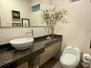 Un baño con lavabo, inodoro y espejo. en Departamento Ricardo Palma, en Lima