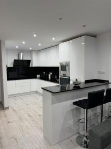 a kitchen with white cabinets and a black counter top at Apartamento de lujo N&C con terraza - Playa Arenal Bol in Calpe