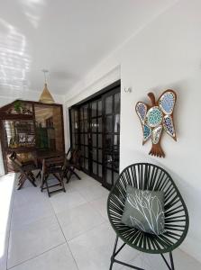 a living room with a chair and a table at Cond Vista Hermosa - Casas 2 quartos by Pipa Centro in Pipa